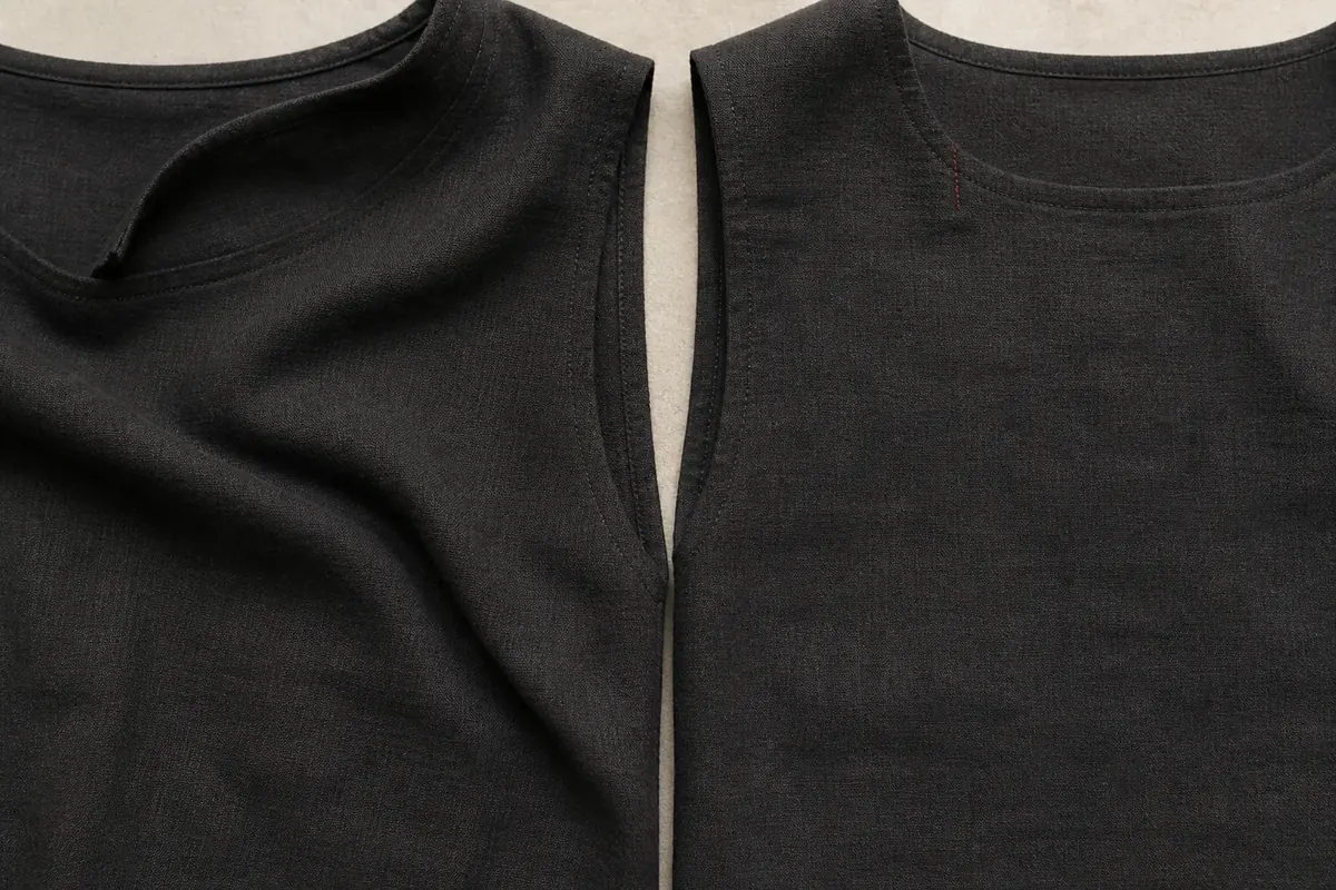 Two dark bodice fronts, the left with its collar riding up and a diagonal fold dragging across the body, the right flat with a rust-red stitch at the shoulder