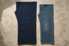 Two identical jean leg panels laid edge to edge and aligned at the top, the left in dark raw indigo and the right pale and softened after washing, and visibly shorter and narrower for it