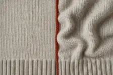 Two knitted panels with ribbed cuffs, the left flat and even, the right rippling and lifting away along its rust-red join